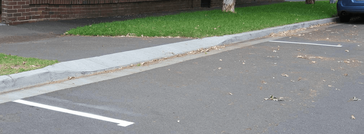 a driveway with white demarcation lines painted on