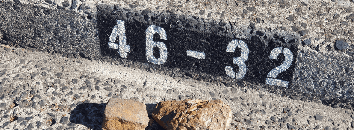 a range of house numbers painted on a kerb
